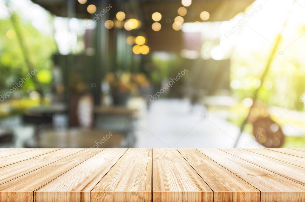 Empty light wood table top with blurred in coffee shop backgroun