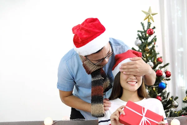 Young man happy surprise closing girlfriend eyes with hands with