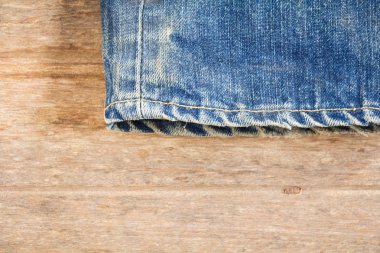 Ahşap arka planda üst üste dizilmiş kot pantolon