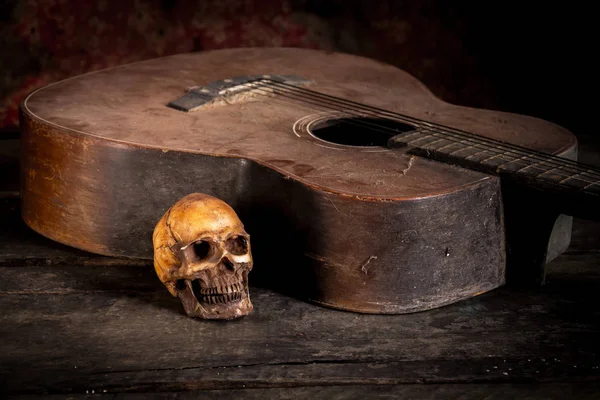 Crânio e guitarra em madeira, ainda vida — Fotografia de Stock