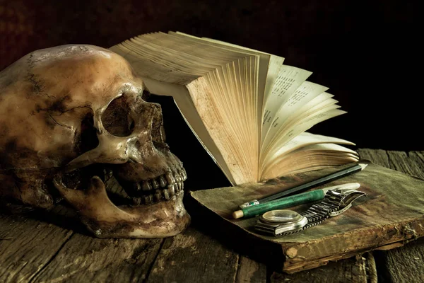 Stilleven met een schedel en boek over houten — Stockfoto