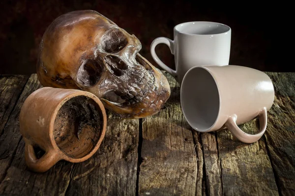 Still Life with a Skull and cup,glass,bottle,kratib rice on wood
