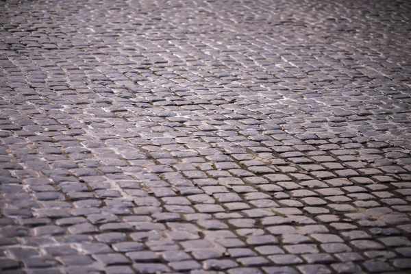 Pavimento adoquinado, pavimento de calle de piedra de fondo con enfoque selectivo. Textura de camino de piedra, adoquines como fondo — Foto de Stock