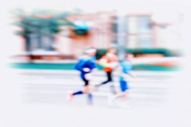 Grup hareketli, bulanıklık etkisi, tanınmayan yüzlere üç genç koşucu. Maratonunu. Spor, fitness ve sağlıklı yaşam konsepti. Modern bir ortam için