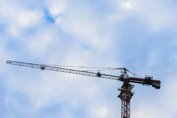 Flecha de construcción grúa para contra cielo azul con nubes para la construcción de la nueva casa muy alta. Para uso de fondo. Mucho lugar para escribir texto —  Fotos de Stock