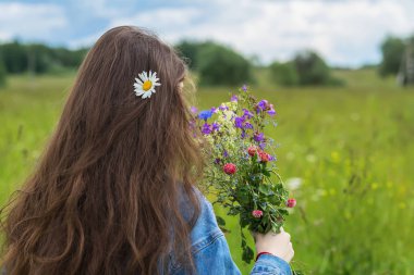 Tanınmayan genç kız bize güzel yaz buket çiçekler onun elinde ayakta. Metniniz için yer