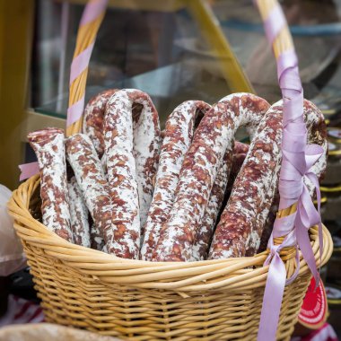 Gastronomi ürünleri gurmeler, geleneksel İtalyan salamı, hasır sepet yakın çekim için. Pazarda gerçek sahne.