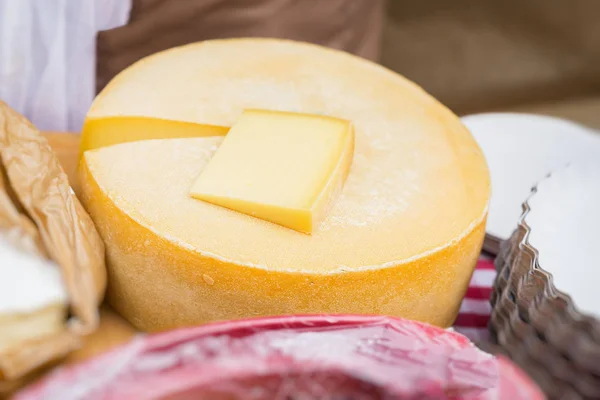 Close-up da roda de queijo e peça cortada no balcão do mercado. Produtos lácteos — Fotografia de Stock