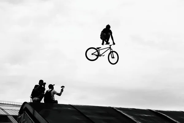 Extrem Sport. BMX bike jumping in sky on high speed, black and white silhouette. — Stock Photo, Image