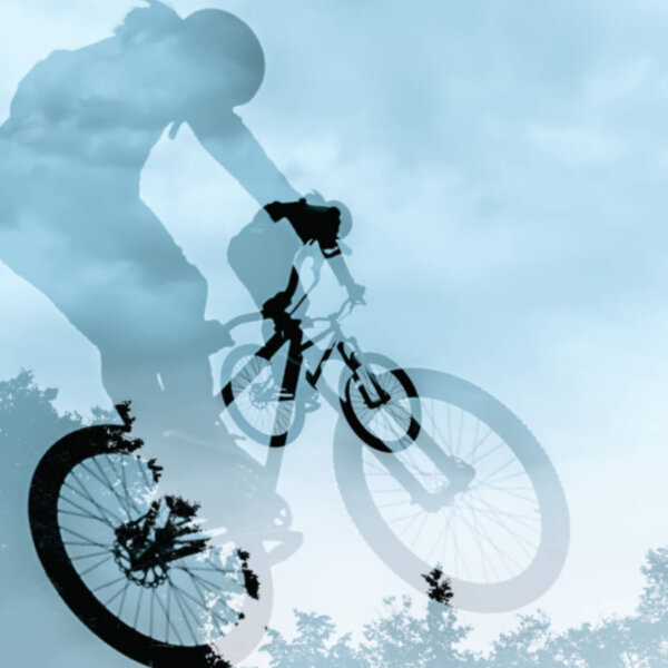 Close-up of double silhouette of unidentified young man doing jump with bmx bike against blue sky. Extrem Sport and risk