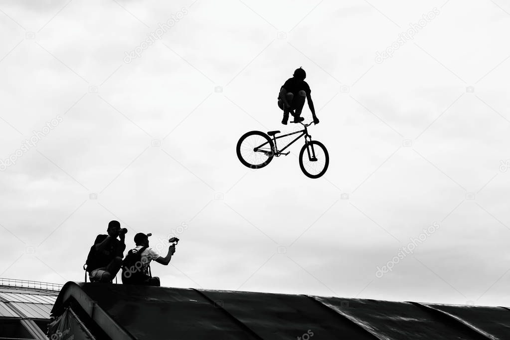Extrem Sport. BMX bike jumping in sky on high speed, black and white silhouette.
