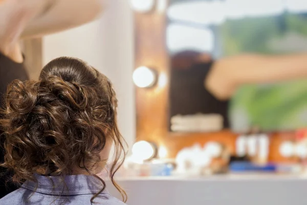 Oigenkännlig flicka tillbaka till oss, flicka i spegeln på frisören gör frisyr, styling från långt hår, frisörsalong, delvis synliga händer master. Selektivt fokus — Stockfoto