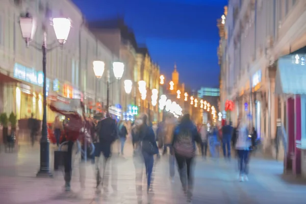 Abstract beeld van onherkenbaar silhouetten van mensen lopen in de stad straat in de avond, winkelen, nachtleven. Stedelijke moderne achtergrond. Wazig bewegingseffect — Stockfoto