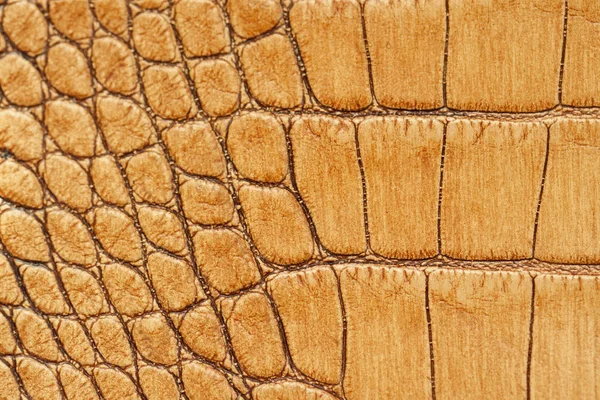 Genuine leather texture with imitation of exotic reptile, light orange brown matte surface, trendy background. Ideal material for footwear, handbags