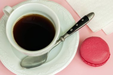 Pembe macaron, acıbadem kurabiyesi ve fincan kahve yakın çekim, üstten görünüm. Romantik sabah, sevgili, kahve molası sahne için hediye