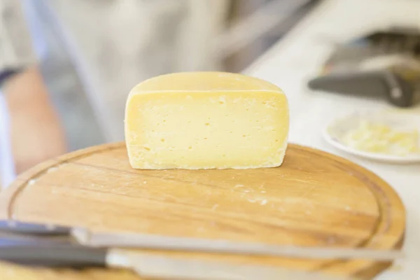 Metade de queijo na placa de madeira do mercado. Produtos lácteos gastronómicos, cena real no mercado alimentar — Fotografia de Stock