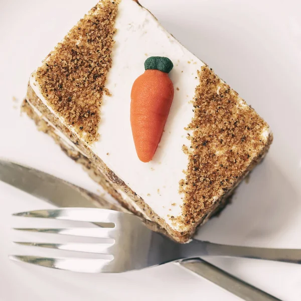 Homemade carrot cake with carrot decorations, fork, knife, cutlery, top view.