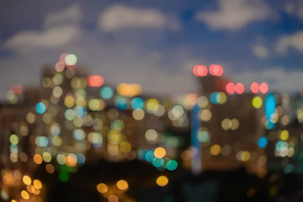 Abstrakta lägenheter, bostäder, hus, mot himlen med moln. Urban natt. Staden på natten med ljus bokeh, suddig fokus, twilight, för bakgrundsanvändning — Stockfoto