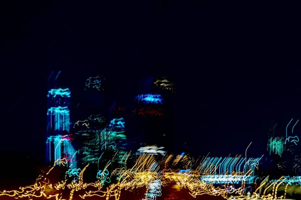 Des gratte-ciel flous. Bâtiments à étages la nuit, fenêtres éclairées. Ville néon moderne à la vitesse de la voiture — Photo