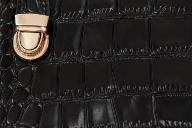 Yakın çekim doku ile hakiki deri siyah çanta sürüngen, altın kilit deri altında kabartmalı. Alışveriş, üretim, yaşam kavramı