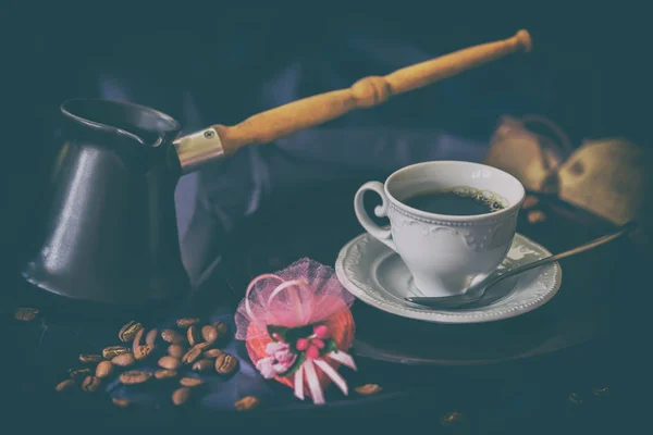 Cup of fresh coffee, turk, coffee beans, chocolate candy in shape of heart. Low key image, vintage style. Selective focus. Concept of valentines, hormone of happiness — Stock Photo, Image
