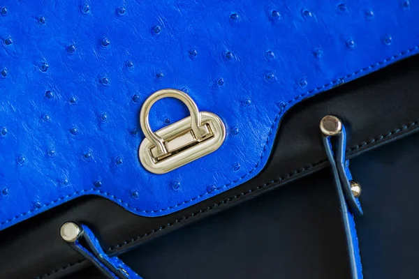 Textura de primer plano del bolso de mano de color azul de moda vívida, cuero genuino con relieve debajo de la piel de avestruz, bloqueo de oro. Concepto de compras, fabricación, estilo de vida —  Fotos de Stock