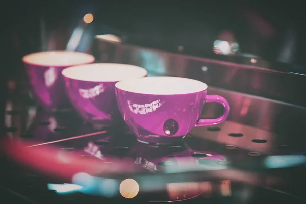 Rosa Tassen auf dem Stand der Kaffeemaschine, Bar. Vintage dunkler Ton, Kaffeezeit, für den Hintergrund — Stockfoto