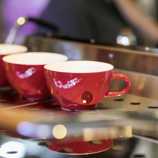 Copos vermelhos no suporte da máquina de café, bar. Tom escuro vintage, tempo de café, fundo quadrado. Cultura do café, tomada de café profissional, serviço, restauração — Fotografia de Stock