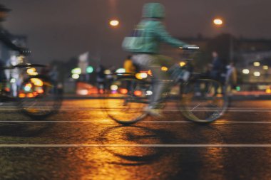 Hareket, bisiklet sürme görüntüsünü bulanıklaştırdı. Soyut tanınmayan insanların siluetleri, gece kenti, aydınlatma bokeh. Modern aktif sağlıklı yaşam tarzı, spor