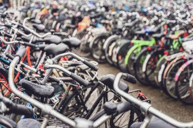 Otoparktaki farklı bisikletlerin bulanık arka planı. Amsterdam 'da park edilmiş bisikletler