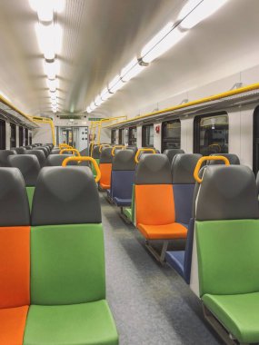 Parlak renkli koltukları olan boş bir tren vagonunun manzarası