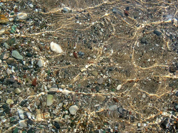 Kieselsteine am Strand im Wasser des Mittelmeeres — Stockfoto