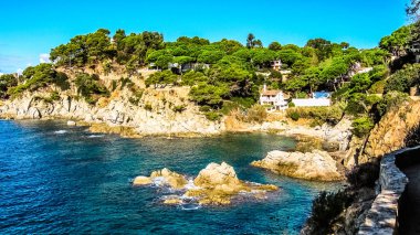 Costa Brava 'da, tatil köyü Lloret de Mar yakınlarındaki dik uçurumları olan bir körfez. Pipolu bir ev. Girona Eyaleti, Katalonya Özerk Topluluğu, İspanya