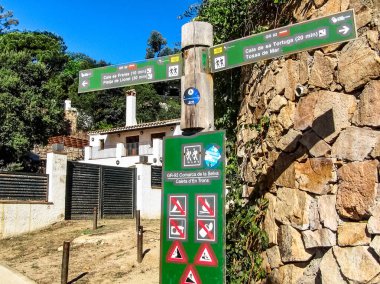 Lloret de Mar, Girona Eyaleti, Katalonya Özerk Topluluğu, İspanya - 7 Ekim 2013: Kosta Brav 'daki Lloret de Mar ve Tossa de Mar tatil beldeleri arasındaki kayalık Akdeniz kıyısındaki yayalar için işaretler