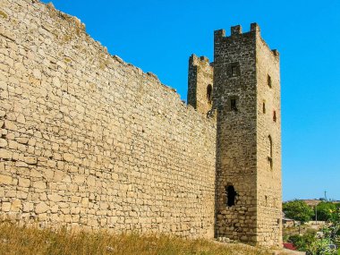 The surviving walls are the ancient Genoese fortress in Feodosia (14th century) on the Black Sea coast in Crimea. Blue sky. Access is free. clipart