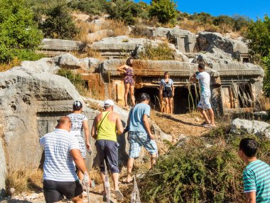 Limyra, Antalya İli, Türkiye - 16 Ekim 2012: Modern Finike kenti yakınlarındaki antik harabe kentteki Lycian mezarları arasında turistler.