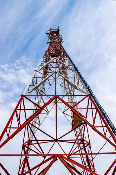 Cell tower on a background of blue sky with clouds. Frame structure. Abstraction. Background.