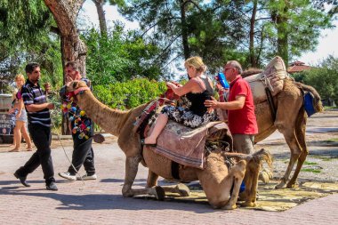 Beldibi, Antalya İli, Türkiye - 13 Ekim 2012: Bir kadın deve üzerinde efendisiyle birlikte