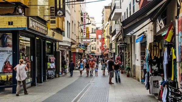Lloret de Mar, Katalonya, İspanya - 5 Ekim 2013: Akdeniz kıyısındaki alışveriş caddelerinden birinde yürüyen turistler.