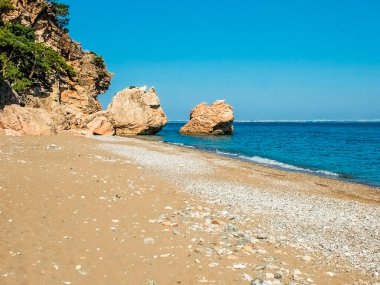 Türkiye 'nin Antalya ilinin Beldibi köyünde vahşi bir plaj. Uzaktan Antalya şehrini görebilirsin..