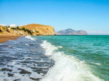 Karadeniz kıyısındaki kum ve çakıl taşı plajı. Kırım. Sunny Valley (Solnechnaya Dolina) yerleşim bölgesi. Arka planda sönmüş kadim volkan Kara-Dag var..