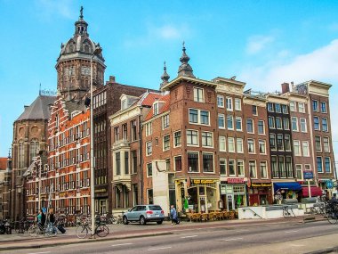 Amsterdam, Hollanda - 5 Mayıs 2007: Prens Hendrik Caddesi (Prins Hendrikkade). Soldaki ise Aziz Niklas Katolik Kilisesi (Sint Nicolaaskerk). Bulutlu.