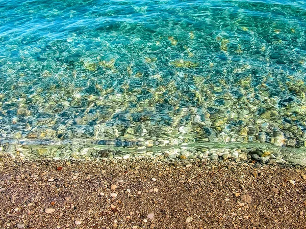 Pebbles and water are connected on the Mediterranean beach in the village of Beldibi in Turkey