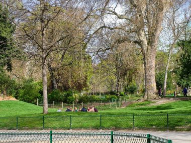 Paris, Fransa - 23 Mart 2014: Baharın başlangıcı. Courcelles Bulvarı 'ndaki ünlü Parc Monceau. Gençler çimlere yerleşti..