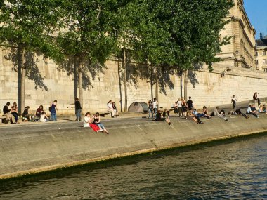 Paris, Fransa - 1 Mayıs 2007: Güneşli bir bahar akşamında Parisliler ve turistler, Cite adasındaki Seine nehrinin kıyısında dinlenirler..