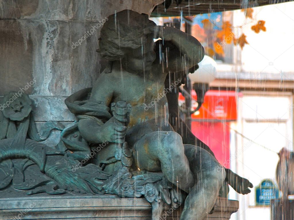 Fragment of the fountain (Fontain du Theatre Francais - Nymphe Fluviale (1867-1874) in the Andre Malraux square in Paris. The child is under the streams  of water. SOFT FOCUS.