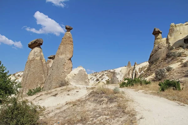 Felsen, die wie Pilze aussehen, dramatisch beleuchtet von einer Sonne in Chawuschin in Kappadokien, Türkei. — Stockfoto