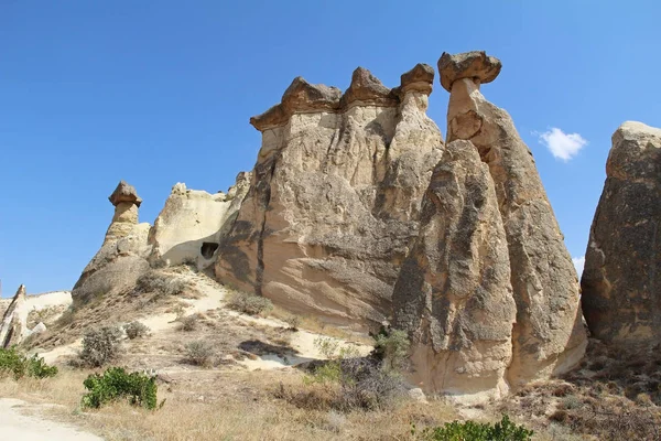 Rocas que parecen setas dramáticamente iluminadas por un sol en Chavushin en Capadocia, Turquía . — Foto de Stock