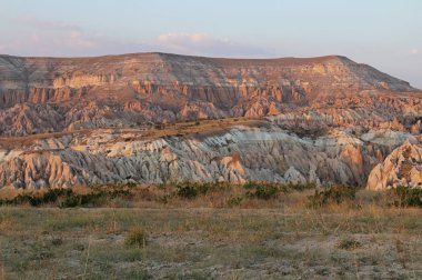 Gün batımında Kapadokya, Göreme Köyü, Türkiye'nin kırmızı kanyonda renkli gül Vadisi Dağ.