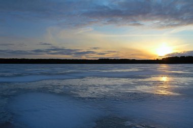 Gün batımında güzel donmuş gölü olan kış manzarası. Renkli gökyüzü. Rusya.